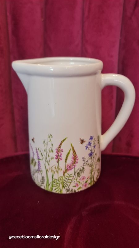 Jug with seasonal hand tied flowers.