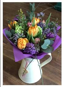 Jug with seasonal hand tied flowers.