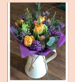 Jug with seasonal hand tied flowers.